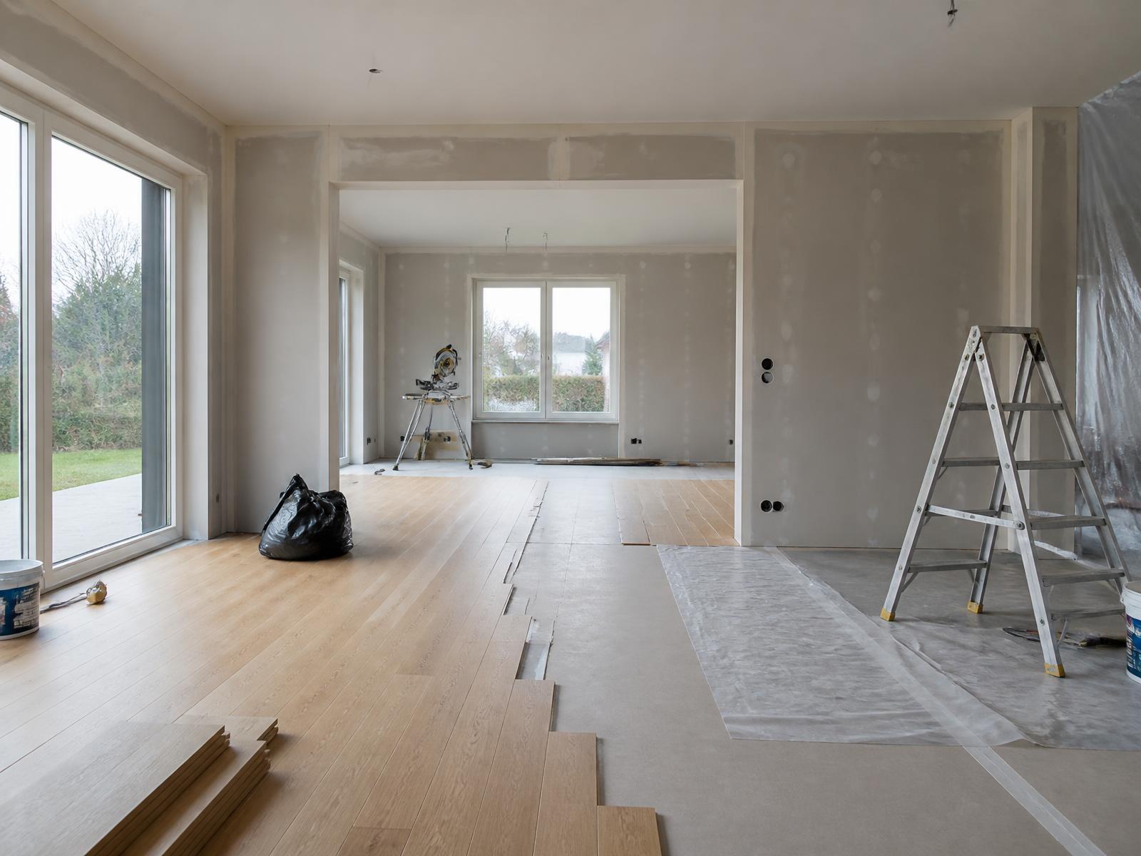 Ljust vardagsrum i en villa under renovering med nylagt ekgolv och nyspacklade väggar